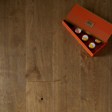 Wooden floor with a small orange box containing three bottles on top