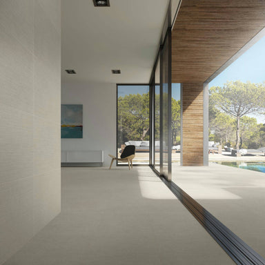 Modern interior with large glass doors leading to a patio with trees and a pool.