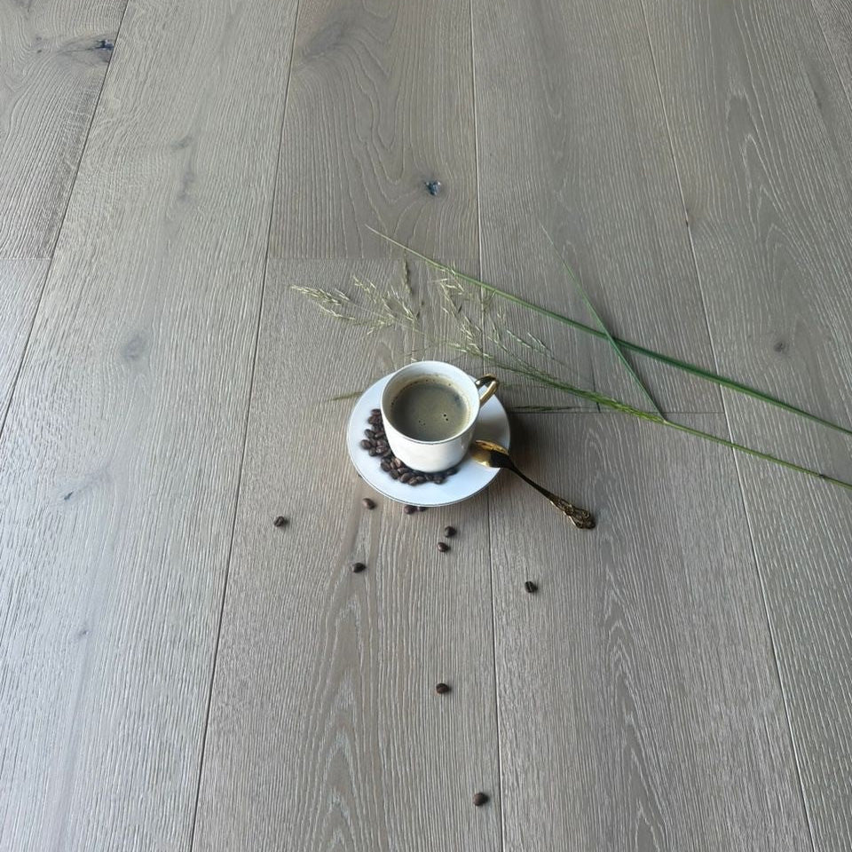 Cup and saucer with scattered coffee beans on a wooden floor